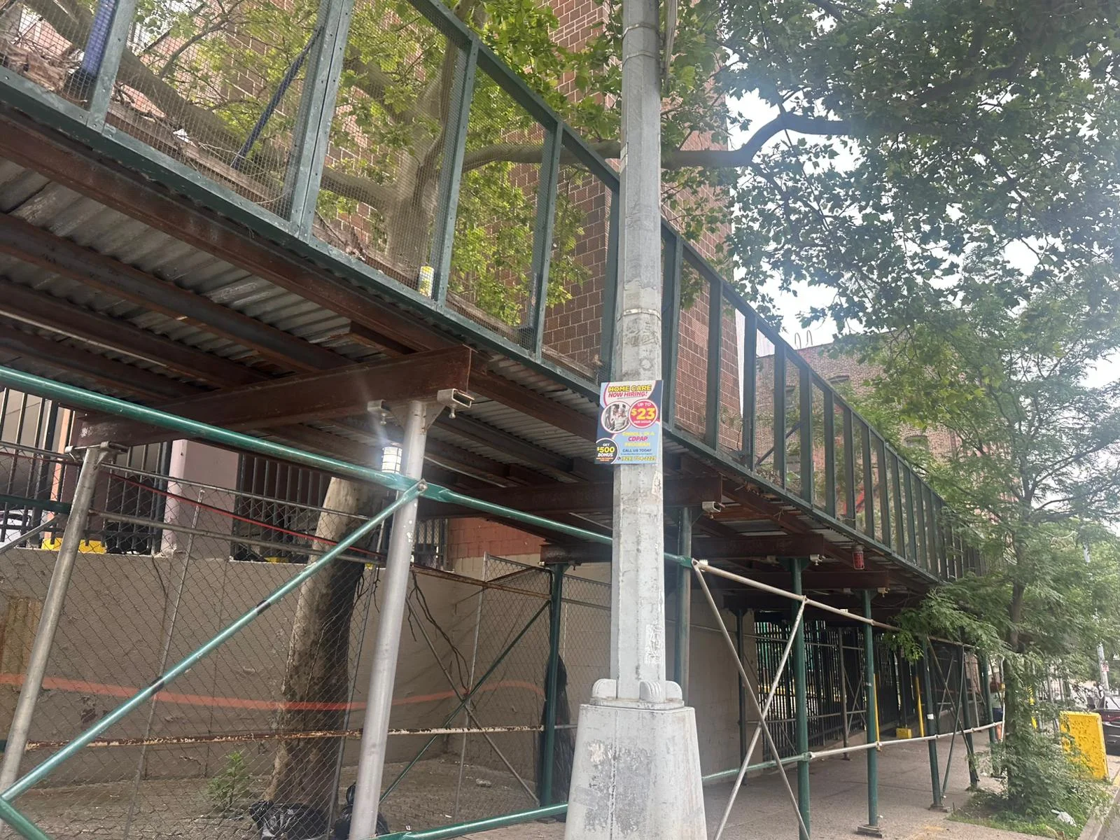 Close-up of Bronx sidewalk shed with metal framing and protective overhead platform